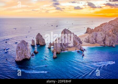 Aerial view of boats speeding by El Arco de Cabo San Lucas, Mexico at sunset, Baja California Sur Stock Photo