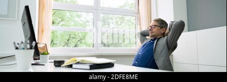 Successful Businessman Leaning Back On A Chair Stock Photo