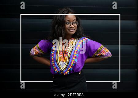 Black african female standing in front of a modern black background Stock Photo