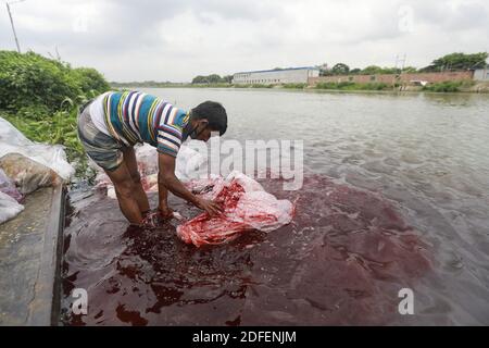 A Bangladeshi man washes plastic waste, which were used to carry chemicals, in the water of the Turag River before recycling it, in Tongi, near Dhaka, Bangladesh, July 9, 2020. Photo by Kanti Das Suvra/ABACAPRESS.COM