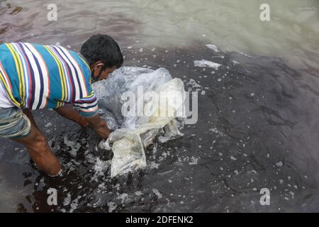 A Bangladeshi man washes plastic waste, which were used to carry chemicals, in the water of the Turag River before recycling it, in Tongi, near Dhaka, Bangladesh, July 9, 2020. Photo by Kanti Das Suvra/ABACAPRESS.COM