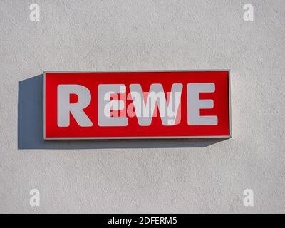 Augsburg Germany - November 13, 2020: REWE logo sign supermarket food shop discounter in Germany. Stock Photo