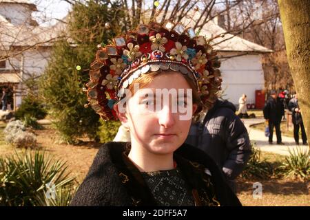 Young girl in Romania wearing an original headpiece, ornate with beads, coins and flowers Stock Photo