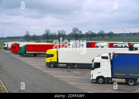 Truck stop. Various types and colors of cabins. Trucks parked in a row. Break in a trip. Stock Photo