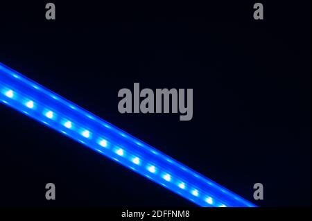 Abstract diagonal blurred blue line of lights on dark background. Stock Photo