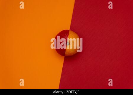 Half red orange on dual tone background. Flat lay. Minimal food concept Stock Photo