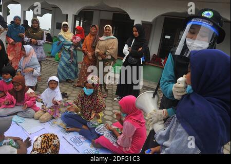 A woman volunteers seen gave point of minds for the childrens which affected by the Sinabung volcano eruption during received the aid from Al Kahfi Foundation volunteers as an charitable aid action for residents of the villages of Kuta Tengah, Berastepu and Gamber (Tiga Serangkai) at the Al-Jihad mosque in Karo, North Sumatra, Indonesia on August 30, 2020. In several news related to the eruption of the Sinabung volcano, humanely some volunteers of Al-Kahfi came to treated psychology of residents, especially for childrens who live on the threshold of a geological disaster hazard zone. Photo by Stock Photo