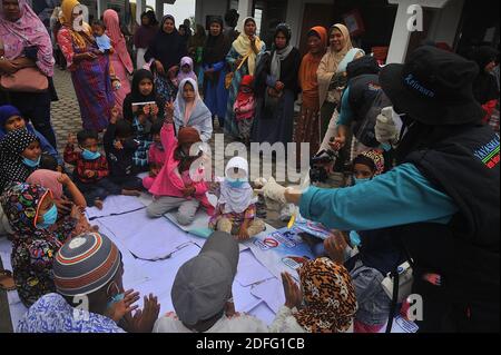 A woman volunteers seen gave point of minds for the childrens which affected by the Sinabung volcano eruption during received the aid from Al Kahfi Foundation volunteers as an charitable aid action for residents of the villages of Kuta Tengah, Berastepu and Gamber (Tiga Serangkai) at the Al-Jihad mosque in Karo, North Sumatra, Indonesia on August 30, 2020. In several news related to the eruption of the Sinabung volcano, humanely some volunteers of Al-Kahfi came to treated psychology of residents, especially for childrens who live on the threshold of a geological disaster hazard zone. Photo by Stock Photo