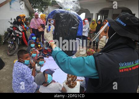 A woman volunteers seen gave point of minds for the childrens which affected by the Sinabung volcano eruption during received the aid from Al Kahfi Foundation volunteers as an charitable aid action for residents of the villages of Kuta Tengah, Berastepu and Gamber (Tiga Serangkai) at the Al-Jihad mosque in Karo, North Sumatra, Indonesia on August 30, 2020. In several news related to the eruption of the Sinabung volcano, humanely some volunteers of Al-Kahfi came to treated psychology of residents, especially for childrens who live on the threshold of a geological disaster hazard zone. Photo by Stock Photo