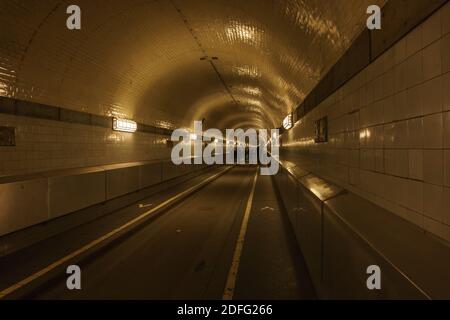 silhouettes of people walking in historic old tunnel under the river elbe in hamburg Stock Photo