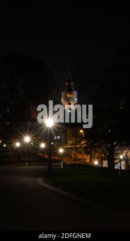 City night scene with road and streetlights in foreground and the cathedral of Mainz in the background Stock Photo