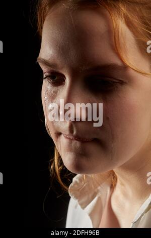 sad woman crying, looking aside on black background, closeup portrait ...