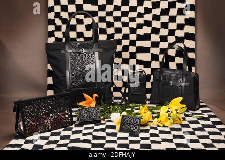 collection of black leather bags are placed on checks background Stock Photo