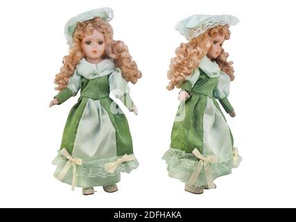 Isolated photo of old-fashioned doll in green dress with hat and curly hair on white background. Stock Photo