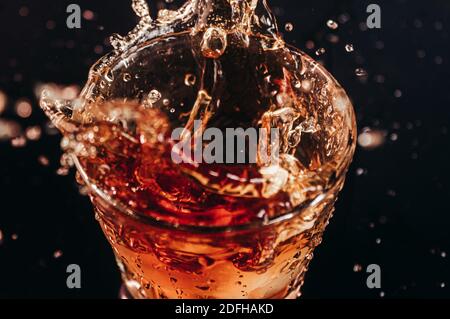 Photo of a liquid spillng in glass on black background. Stock Photo