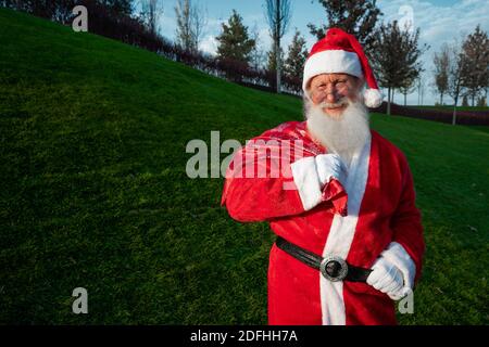 Close up portrait of senior happy man in santa claus costume returns to camera and smiles. New Year's mood. Stock Photo