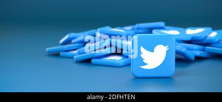 Logos of the social media messaging site and app Twitter on a heap. One tile standing upright in front. Web banner size with copy space - Selective fo Stock Photo