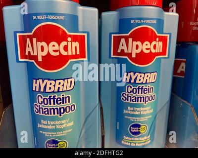 Viersen, Germany - May 9. 2020: Closeup of bottles Alpecin caffeine dandruff shampoo in shelf of german supermarket