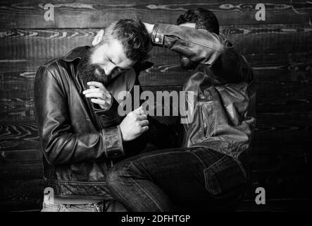 Men brutal hooligans wear leather jackets fighting. Physical attack. Men bearded hipster fighting. Attack and defence. Aggressive hooligan fighting with strong bully man. Street fight concept. Stock Photo