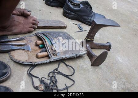 Tools of local indian cobbler. old leather pouch, anvil for shoe repair, threads, chisel etc. natural shot Stock Photo