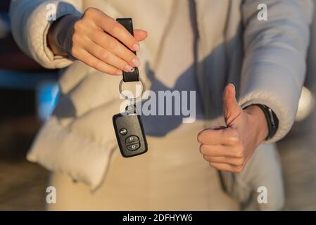 Woman holding key of her new car. Woman has got driving license and ready to drive Stock Photo