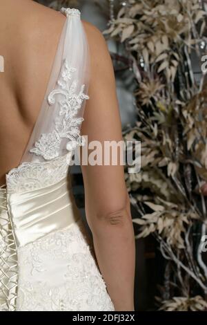 Bride's dress with a beautiful pattern on the shoulder close-up, back view Stock Photo