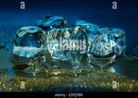 Melting frozen ice cubes illuminated with blue coloured LED light in the  dark Stock Photo - Alamy