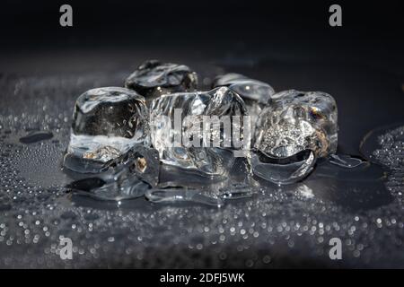 Melting frozen ice cubes illuminated with blue coloured LED light in the  dark Stock Photo - Alamy