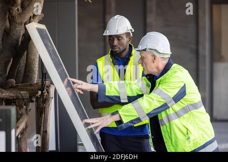 Man showing solar panels technology to engineer team Stock Photo