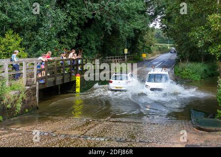 Cars splashing through Rufford Ford on Rufford Lane, Rufford Country Park, Nottinghamshire, UK. Stock Photo