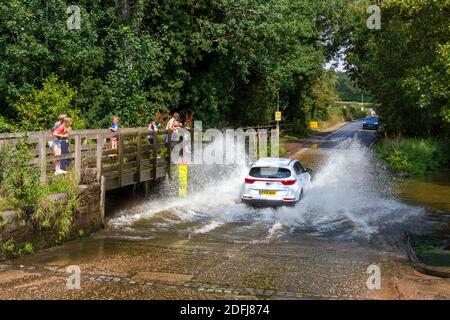 Car splashing through Rufford Ford, Rufford Lane, Rufford Country Park, Nottinghamshire, UK. Stock Photo