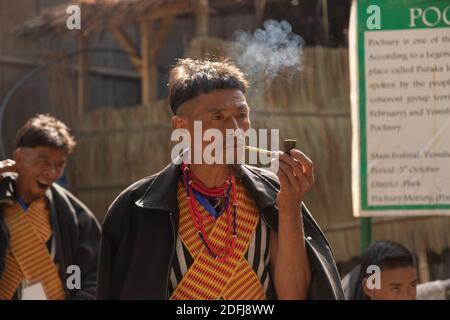 A Naga Tribesman smoking a pipe at Kisama village in Nagaland India on 2 December 2016 Stock Photo