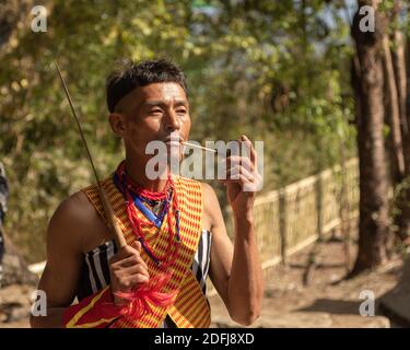 A Naga Tribesman smoking a pipe at Kisama village in Nagaland India on 2 December 2016 Stock Photo