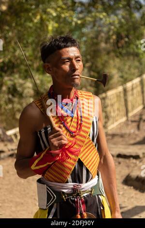 A Naga Tribesman smoking a pipe at Kisama village in Nagaland India on 2 December 2016 Stock Photo