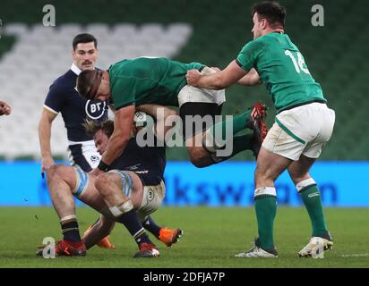 Ireland's CJ Stander (centre right) gathers possession from Scotland's Jonny Gray (centre left) during the Autumn Nations Cup match at the Aviva Stadium, Dublin. Stock Photo