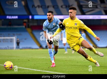 Fulham's Antonee Robinson (right) and Manchester City's Riyad Mahrez battle for the ball during the Premier League match at the Etihad Stadium, Manchester. Stock Photo