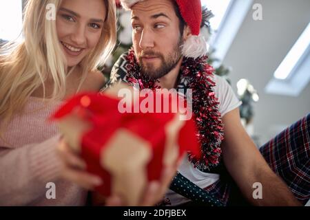 A lovely couple posing for a photo with Xmas presents on a beautiful holiday morning at home. Christmas, relationship, love, together Stock Photo
