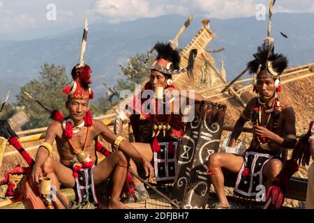 A group of naga warriors siting and drinking in a traditional naga hut in Nagaland India on 2 December 2016 Stock Photo