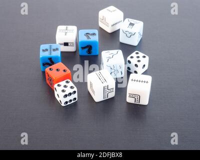 Set of several dice of different colors and shapes on a black background. Concept around board games, sharing and competition. Stock Photo