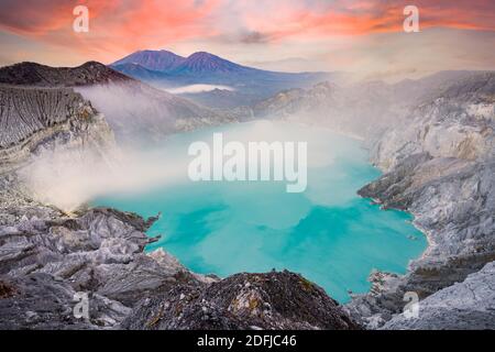 View from above, stunning aerial view of the Kawah Ijen volcano complex at sunset with the blue acid lake. Stock Photo