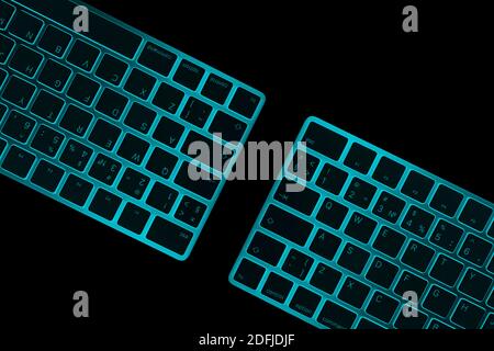 Closeup of a two modern blue computer keyboard keys isolated on black background. Close up view of a business workplace with wireless computer keyboar Stock Photo