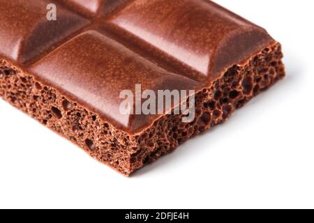 Piece of aerated chocolate bar close up on white background Stock Photo