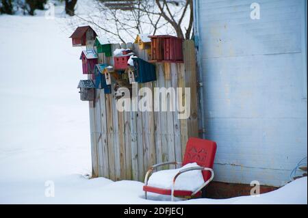 Backyard birdhouses and lawn chair covered by snow Stock Photo