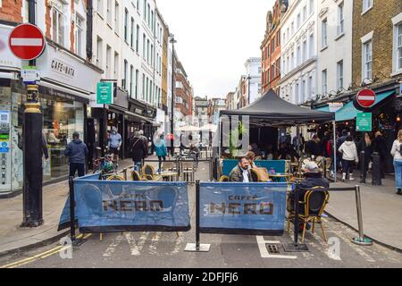 People at cafes and restaurants in Old Compton Street, Soho, London. Businesses have reopened as England ends its month-long coronavirus lockdown. Stock Photo
