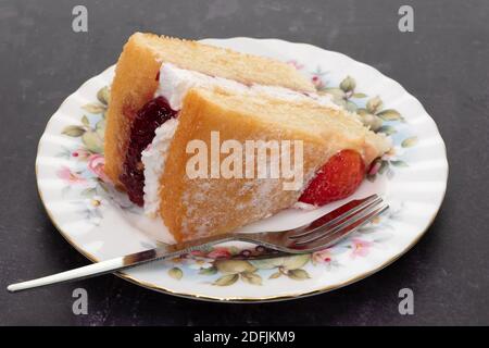 A slice of Victoria sponge cake on an ornate antique plate -  white background Stock Photo