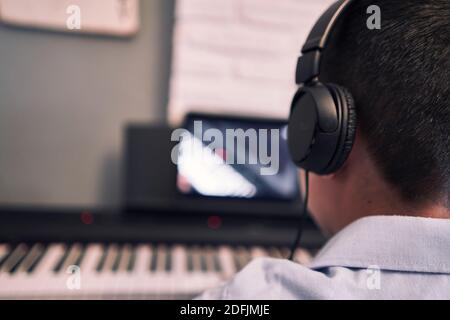 Child learning piano online lessons in quarantine . Coronavirus life style Stock Photo