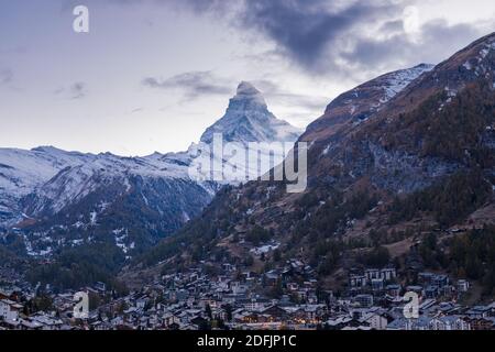 The Swiss village of Zermatt in Valais in autumn at dusk, with the Matterhorn and the Alpine mountain range in the background. Stock Photo