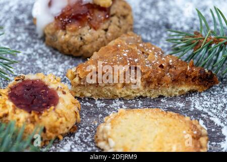 Close-up of various Christmas cookies surrounded with powdered sugar and fir branches Stock Photo