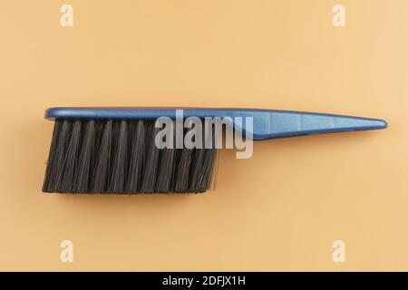 Black brush with blue handle on beige background. Flat lay Stock Photo
