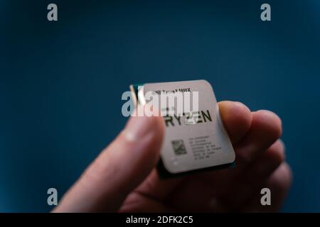 Valencia, Spain - December 04, 2020: Hand holding AMD Ryzen 5900x processor. New coonsumer  Zen 3, 7 nanometer desktop CPU by AMD. Very popular proces Stock Photo